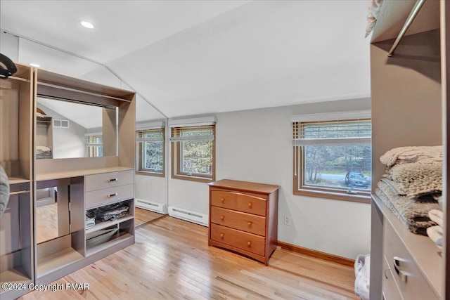 interior space featuring a baseboard radiator, lofted ceiling, light wood-style floors, and visible vents