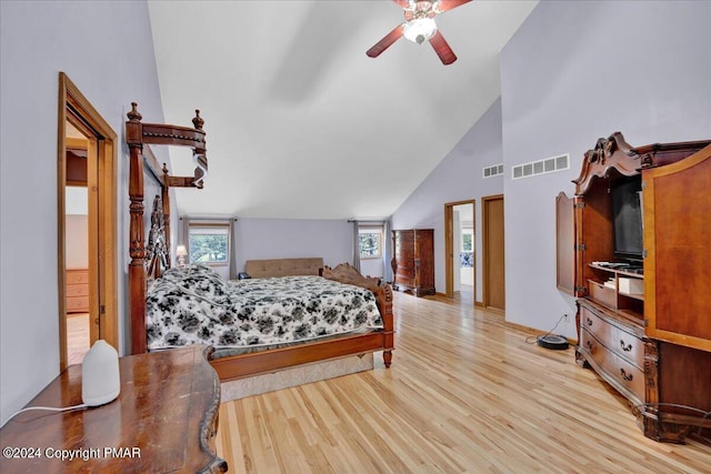 bedroom featuring light wood finished floors, visible vents, high vaulted ceiling, and ceiling fan