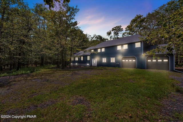 traditional home featuring a garage, a yard, and driveway