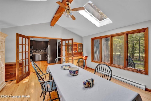 dining room featuring a ceiling fan, french doors, vaulted ceiling with skylight, light wood-style floors, and baseboard heating