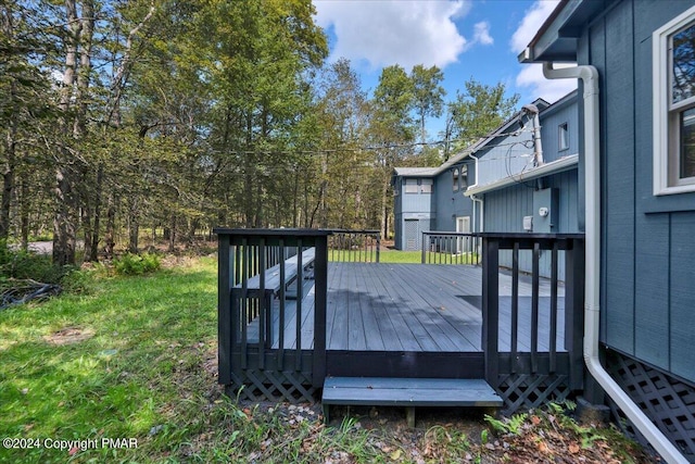 wooden terrace featuring a lawn