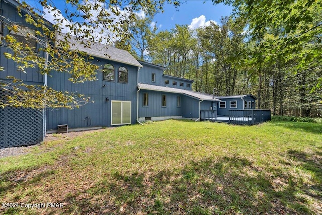 back of house featuring a yard and a wooden deck