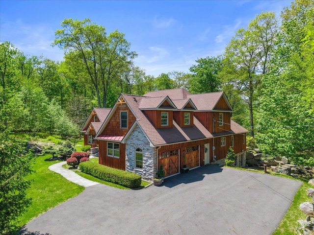 127 Timber Lake Dr, Canadensis, PA 18325 - view of front of home with stone siding, driveway, an attached garage, and a standing seam roof