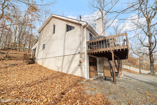 view of side of property featuring a chimney and a deck