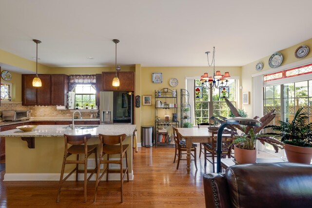 2772 Sheffield Dr, Easton, PA 18040 - kitchen featuring refrigerator with ice dispenser, light wood finished floors, decorative backsplash, and hanging light fixtures