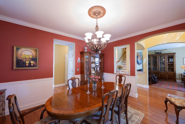 2772 Sheffield Dr, Easton, PA 18040 - dining space featuring arched walkways, a chandelier, ornamental molding, stairs, and wood finished floors