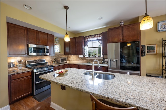 2772 Sheffield Dr, Easton, PA 18040 - kitchen featuring appliances with stainless steel finishes, decorative backsplash, dark wood-style flooring, light stone countertops, and pendant lighting