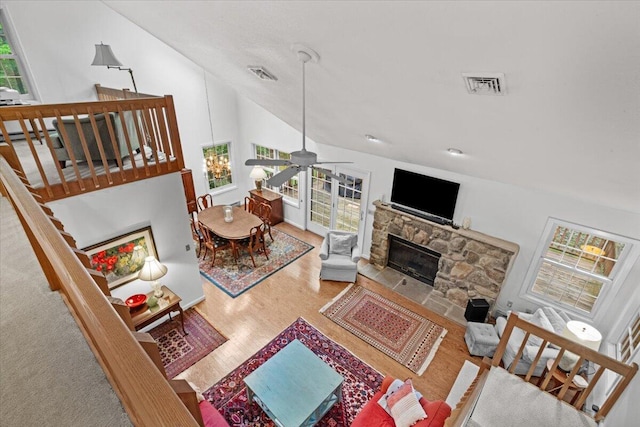 606 Buck Cir, Buck Hill Falls, PA 18323 - living room featuring wood finished floors, healthy amount of natural light, a stone fireplace, a ceiling fan, and vaulted ceiling