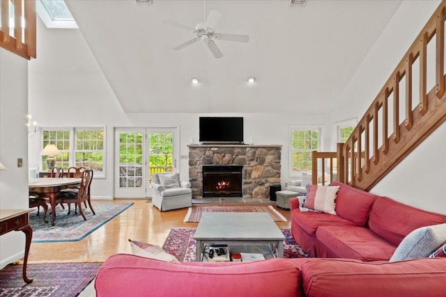 606 Buck Cir, Buck Hill Falls, PA 18323 - living area featuring high vaulted ceiling, wood finished floors, ceiling fan, a stone fireplace, and a skylight