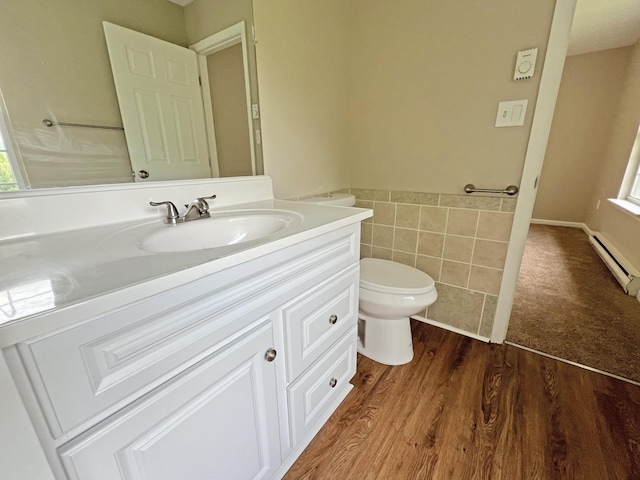 2138 Hill Rd, Effort, PA 18330 - bathroom featuring vanity, tile walls, baseboard heating, a wainscoted wall, and wood finished floors