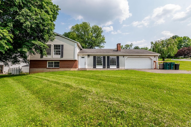 23 Devon Dr, Easton, PA 18045 - split level home featuring asphalt driveway, an attached garage, a front yard, a chimney, and brick siding