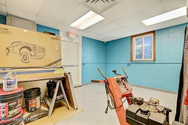 interior space featuring concrete block wall, visible vents, and a paneled ceiling