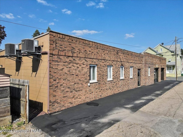 view of property with community garages and central AC unit