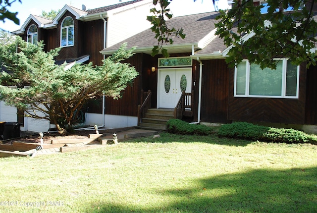 view of front of property featuring roof with shingles, a front lawn, and entry steps