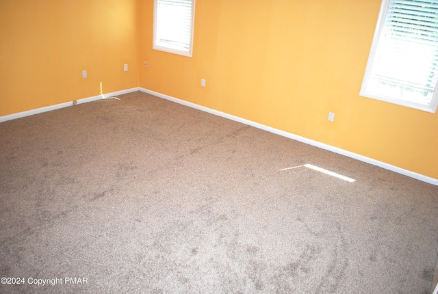 carpeted empty room with baseboards