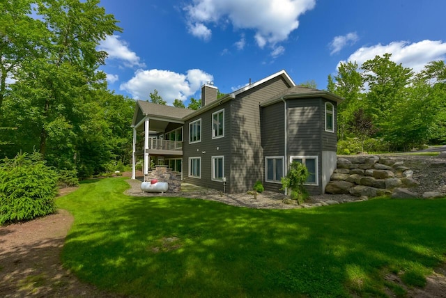 177 Wolf Hollow Rd, Lake Harmony, PA 18624 - rear view of house with a lawn, a balcony, and a chimney