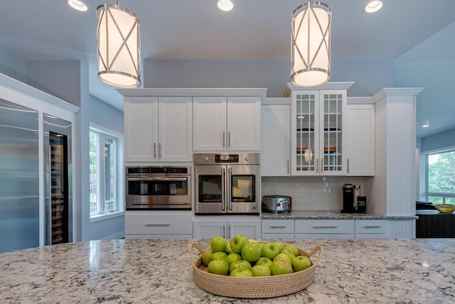 177 Wolf Hollow Rd, Lake Harmony, PA 18624 - kitchen with glass insert cabinets, decorative light fixtures, white cabinets, appliances with stainless steel finishes, and light stone countertops
