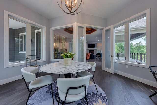 177 Wolf Hollow Rd, Lake Harmony, PA 18624 - dining area with a fireplace, dark wood-type flooring, a notable chandelier, and baseboards