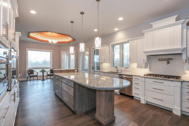 177 Wolf Hollow Rd, Lake Harmony, PA 18624 - kitchen with dark wood finished floors, a kitchen island, decorative backsplash, appliances with stainless steel finishes, and white cabinetry