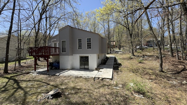 view of property exterior featuring a patio area and a wooden deck