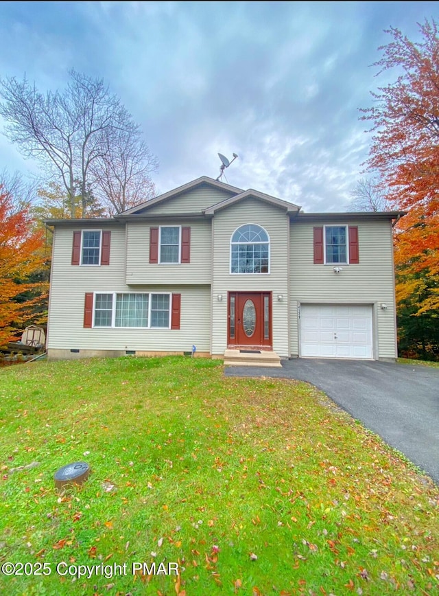 view of front of house with an attached garage, aphalt driveway, and a front yard