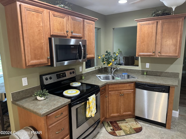 kitchen with a sink, brown cabinetry, and stainless steel appliances