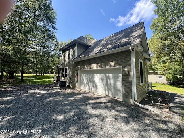 view of side of property featuring an attached garage and driveway