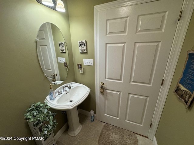 bathroom featuring a sink, baseboards, and tile patterned flooring