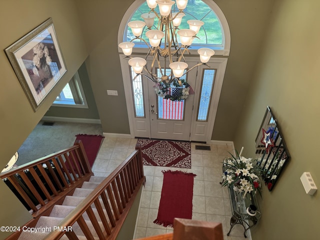 tiled foyer with an inviting chandelier, baseboards, visible vents, and a wealth of natural light