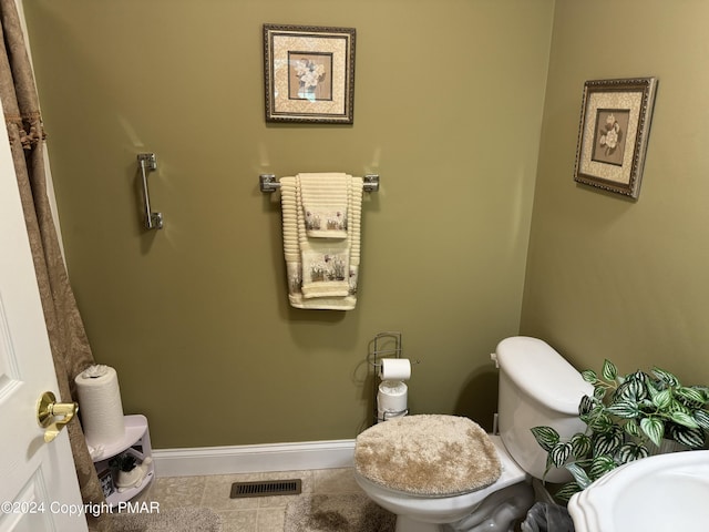 bathroom with tile patterned flooring, visible vents, toilet, and baseboards