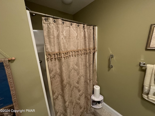 bathroom featuring a shower with shower curtain and baseboards