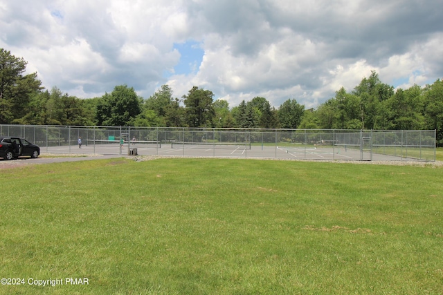 view of yard featuring a tennis court and fence