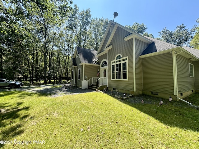 view of side of property with a lawn and a shingled roof