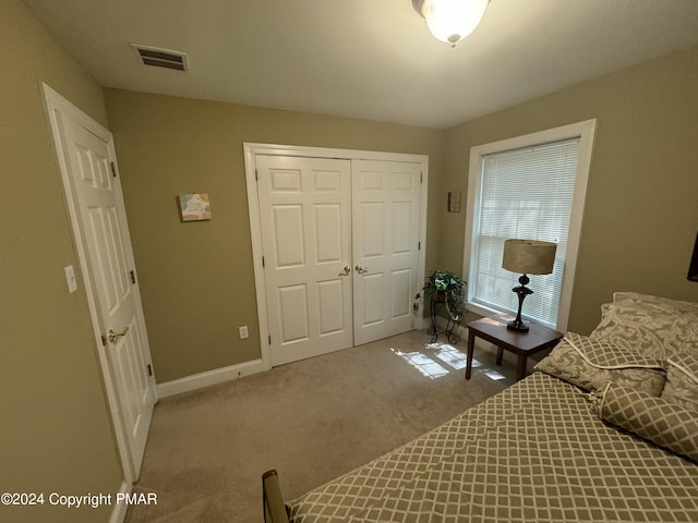 bedroom with carpet, visible vents, a closet, and baseboards