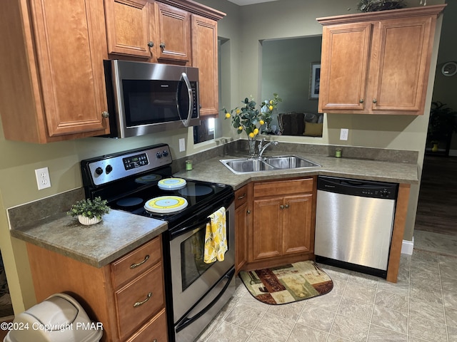 kitchen featuring a sink, stainless steel appliances, and brown cabinetry