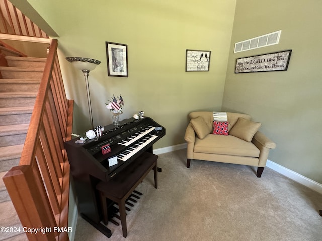 sitting room featuring visible vents, carpet flooring, stairs, and baseboards