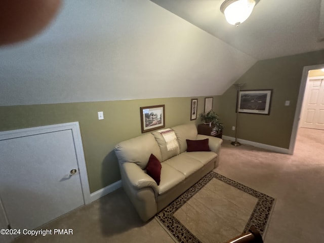 living area with carpet, baseboards, and vaulted ceiling