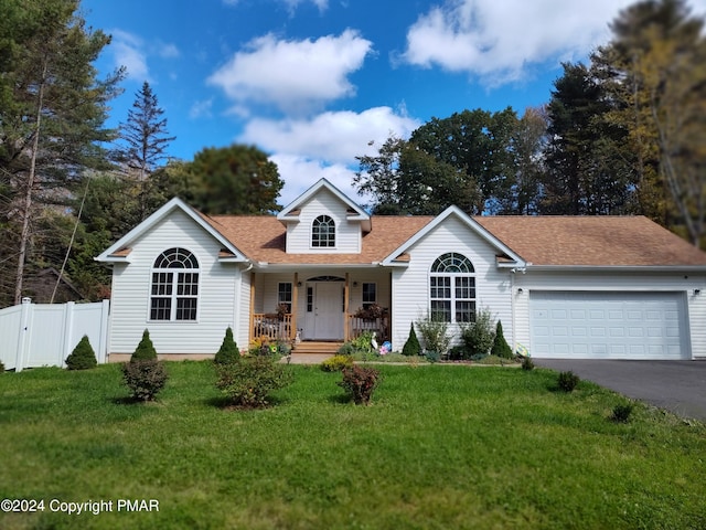 view of front of house featuring covered porch, a front yard, fence, a garage, and driveway