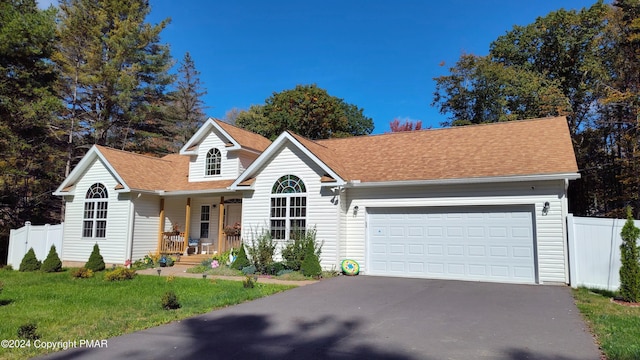 view of front of house with a garage, a front yard, fence, and driveway