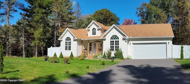 view of front of home with an attached garage, a front lawn, fence, and aphalt driveway