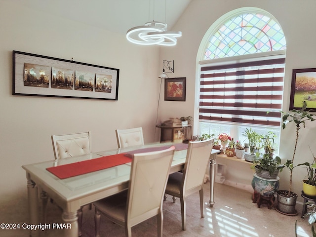 dining space with vaulted ceiling and an inviting chandelier