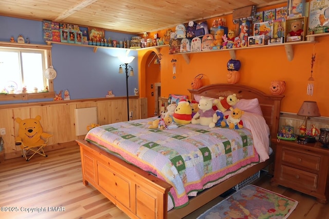 bedroom featuring arched walkways, wooden ceiling, and wood finished floors