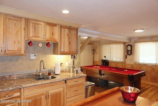 kitchen with light stone countertops, sink, light brown cabinets, and backsplash