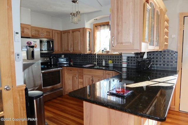 kitchen featuring tasteful backsplash, hanging light fixtures, kitchen peninsula, and appliances with stainless steel finishes