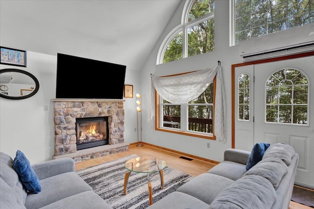 318 N Arrow Dr, Pocono Lake, PA 18347 - living area featuring a wall unit AC, high vaulted ceiling, wood finished floors, and a stone fireplace