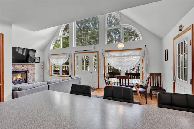 318 N Arrow Dr, Pocono Lake, PA 18347 - living room featuring a stone fireplace, high vaulted ceiling, wood finished floors, and a wall mounted air conditioner