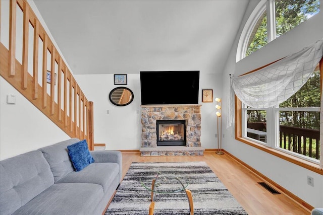 318 N Arrow Dr, Pocono Lake, PA 18347 - living room with a stone fireplace, wood finished floors, stairs, and high vaulted ceiling