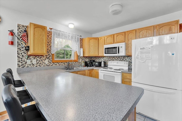 318 N Arrow Dr, Pocono Lake, PA 18347 - kitchen featuring white appliances, a peninsula, decorative backsplash, a breakfast bar area, and light brown cabinetry