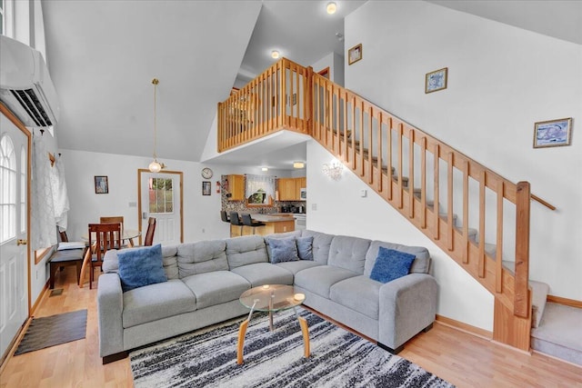 318 N Arrow Dr, Pocono Lake, PA 18347 - living area featuring high vaulted ceiling, light wood-style floors, stairway, and a wall mounted air conditioner
