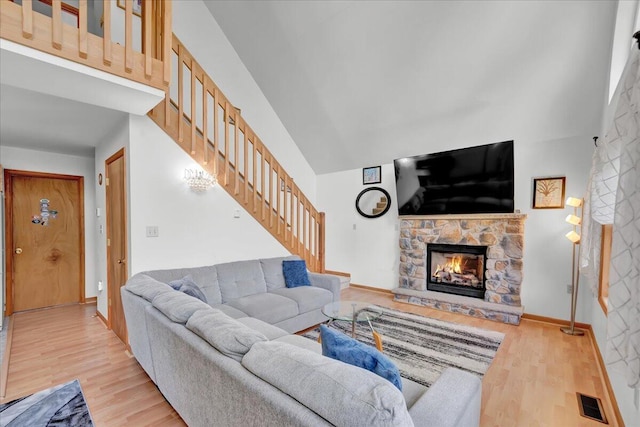318 N Arrow Dr, Pocono Lake, PA 18347 - living area featuring a fireplace, stairway, light wood-type flooring, and high vaulted ceiling